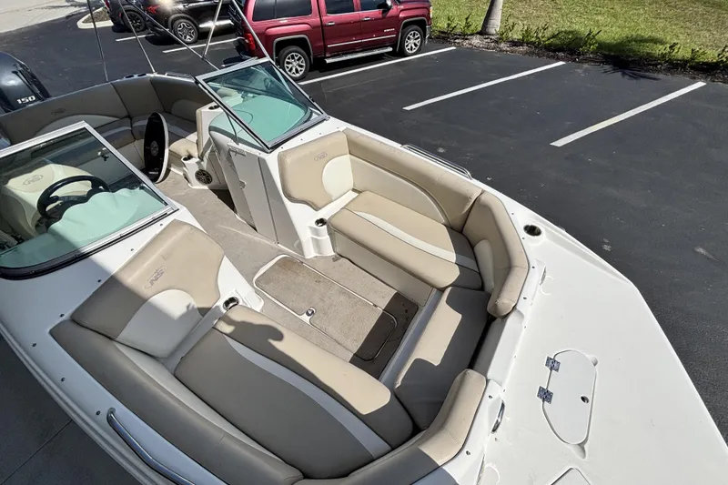 Slide: The Image of 2015 NauticStar 223 DC boat interior with beige seating and open deck view. - 32