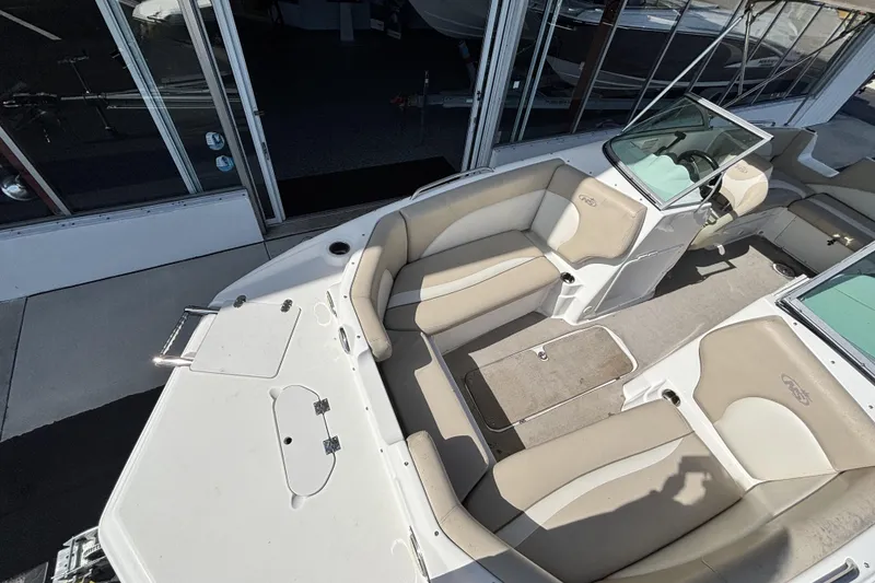 Slide: The Image of 2015 NauticStar 223 DC boat interior with beige seating and storage compartments. - 33