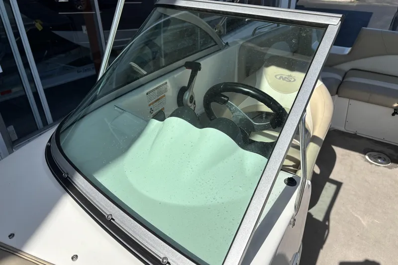 Slide: The Image of 2015 NauticStar 223 DC boat interior with steering wheel and seating. - 34