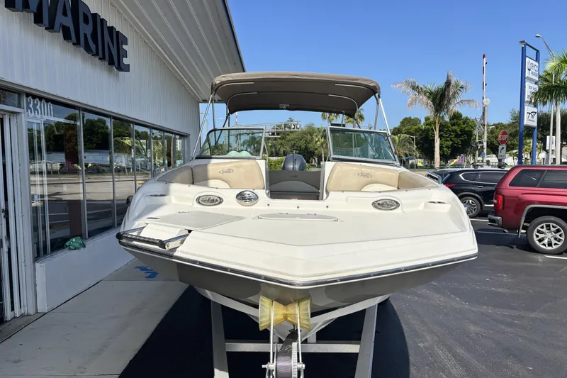 Slide: The Image of 2015 NauticStar 223 DC boat displayed outside a marine dealership. - 5