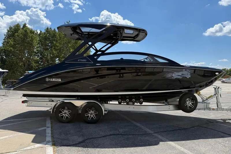 The Image of 2026 Yamaha Boats 275SD on trailer, sleek black design under clear blue sky. - 0