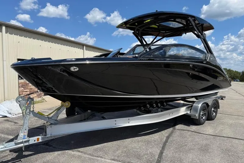 Slide: The Image of 2026 Yamaha Boats 275SD in black on a trailer, parked outdoors under a blue sky. - 3