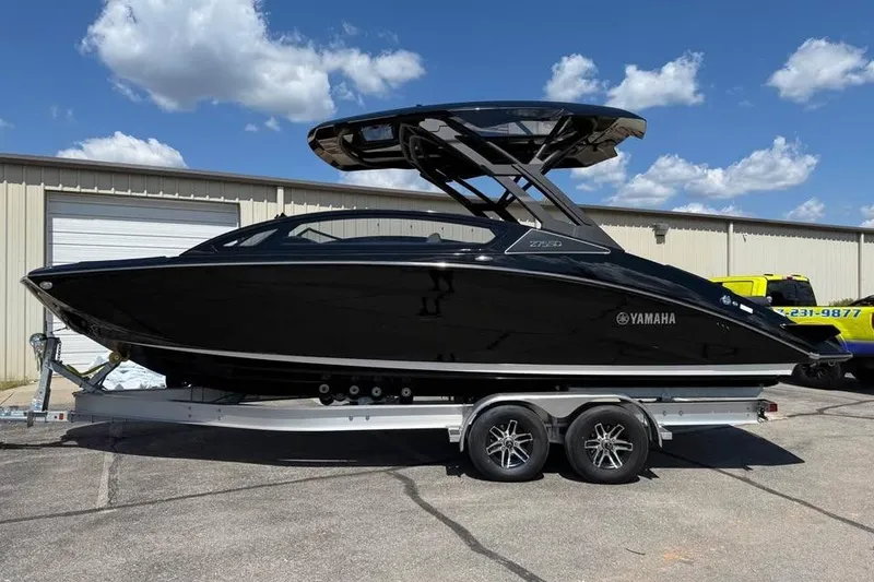 Slide: The Image of 2026 Yamaha Boats 275SD in black on trailer, parked outdoors under blue sky. - 4