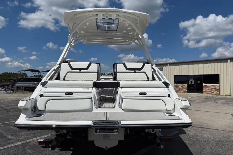 Slide: The Image of 2026 Yamaha Boats 275SD, rear view, showcasing sleek design and spacious seating under a clear sky. - 5