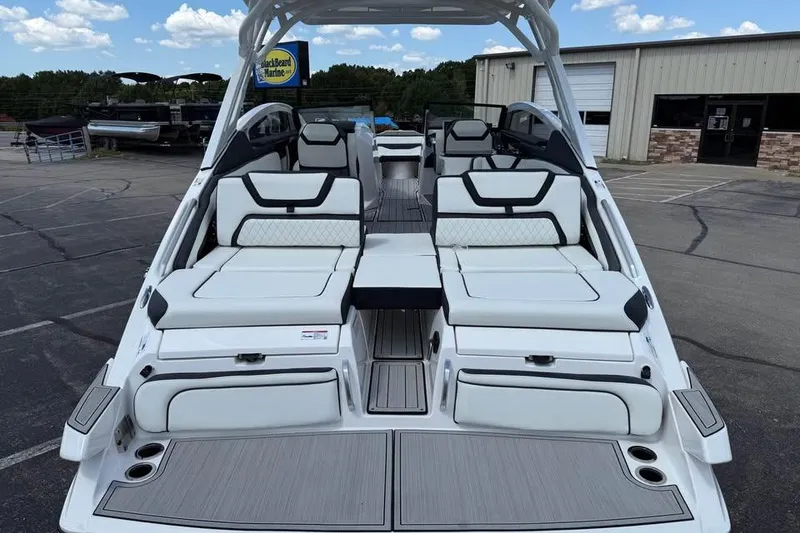 Slide: The Image of 2026 Yamaha Boats 275SD with luxurious seating and sleek design at a marina. - 6