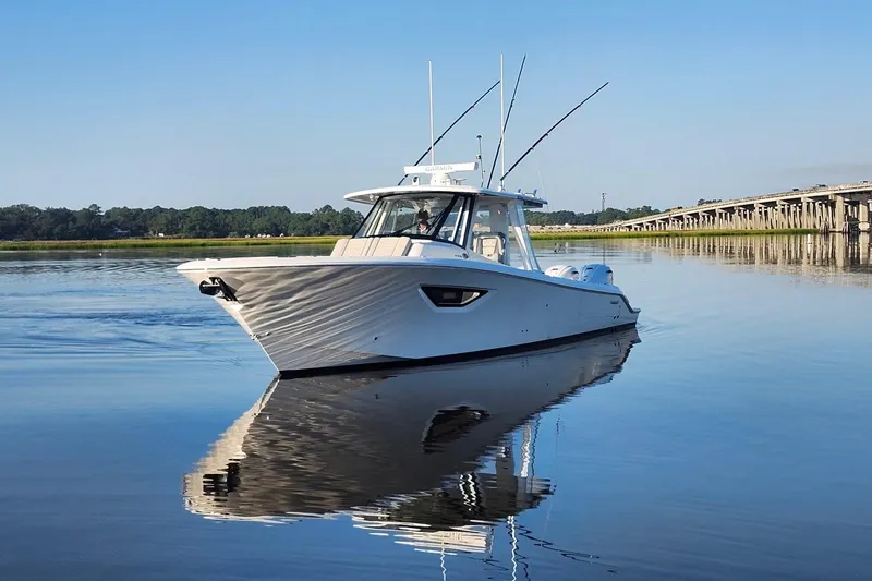 Slide: The Image of 2023 Pursuit S 378 Sport boat on calm water near a bridge. - 13