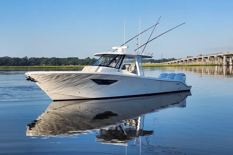 Slide: The Image of 2023 Pursuit S 378 Sport boat on calm water near a bridge. - 15