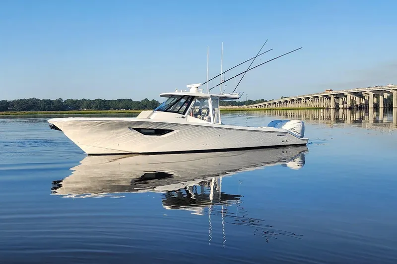 Slide: The Image of 2023 Pursuit S 378 Sport boat on calm water near a bridge. - 17