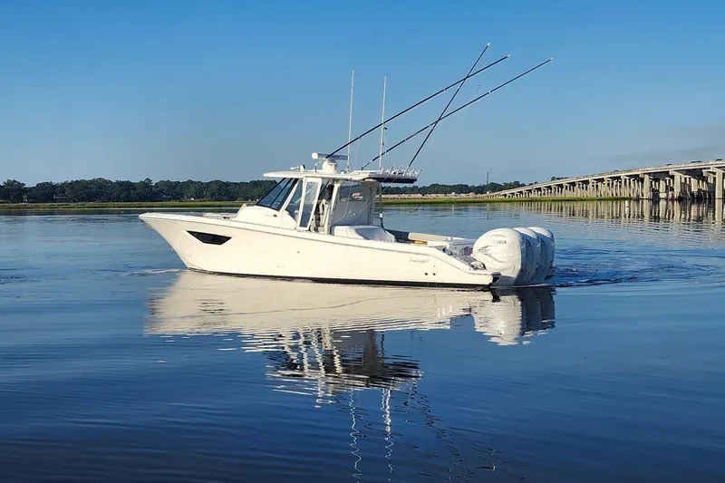 Slide: The Image of 2023 Pursuit S 378 Sport boat on calm water near a bridge. - 21