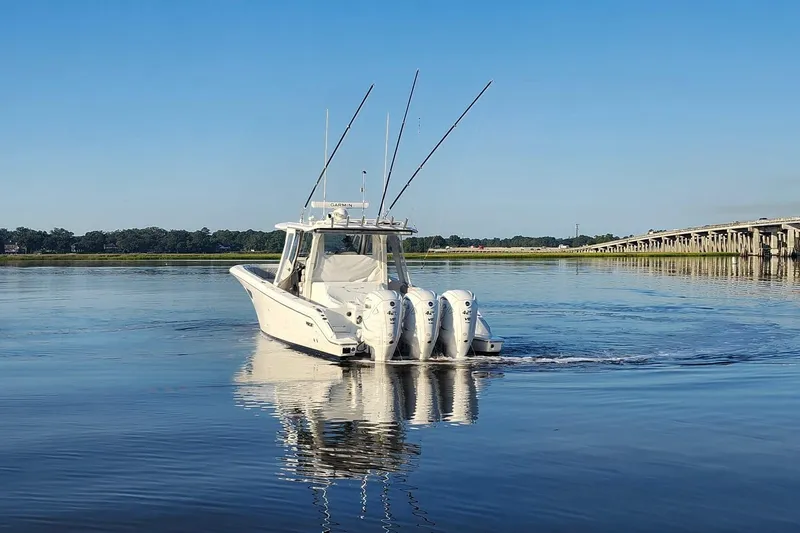 Slide: The Image of 2023 Pursuit S 378 Sport boat on calm water near a bridge. - 24