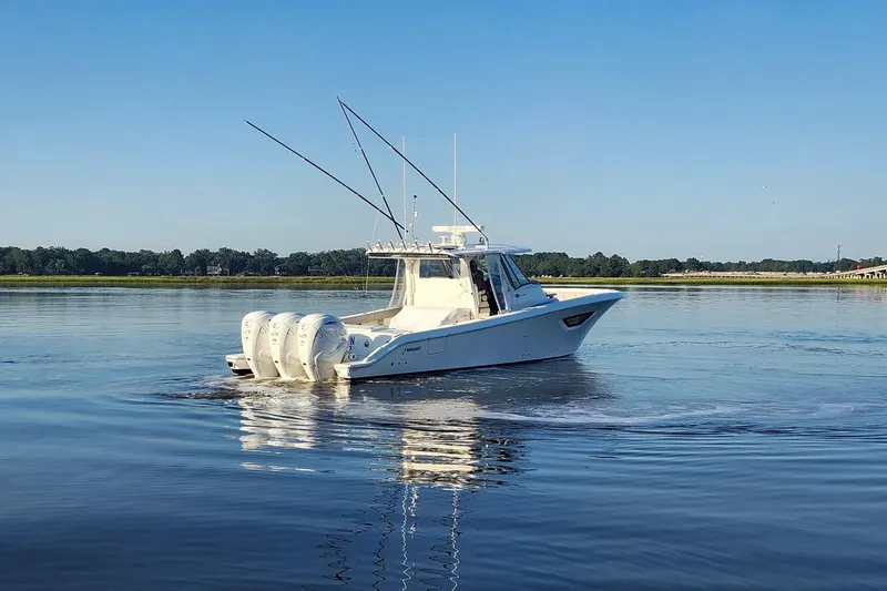 Slide: The Image of 2023 Pursuit S 378 Sport boat cruising on calm water under clear blue sky. - 28