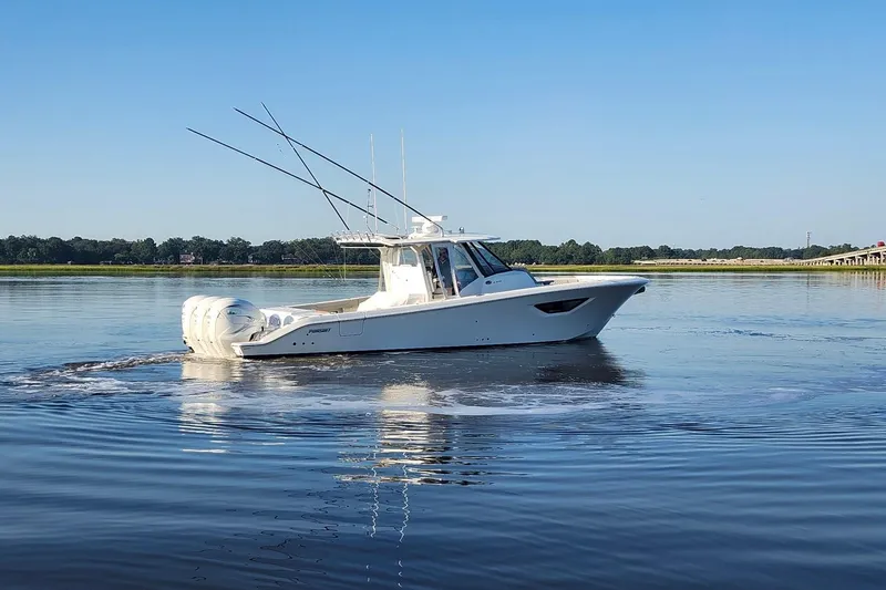 Slide: The Image of 2023 Pursuit S 378 Sport boat cruising on calm water under clear blue sky. - 30