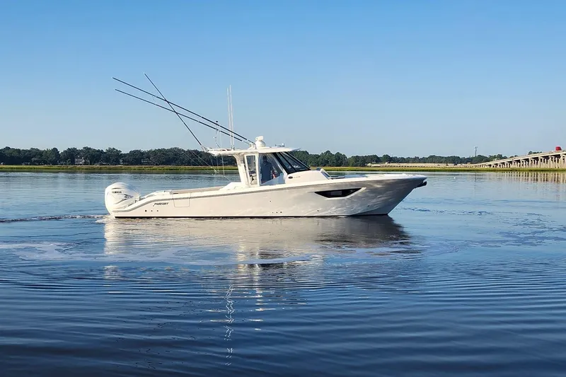 Slide: The Image of 2023 Pursuit S 378 Sport boat cruising on calm water under clear blue sky. - 31