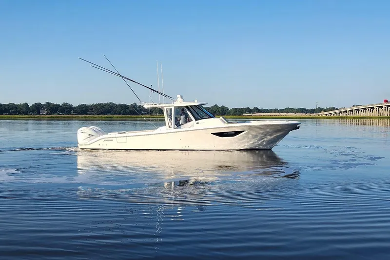 Slide: The Image of 2023 Pursuit S 378 Sport boat cruising on calm water under clear blue sky. - 32