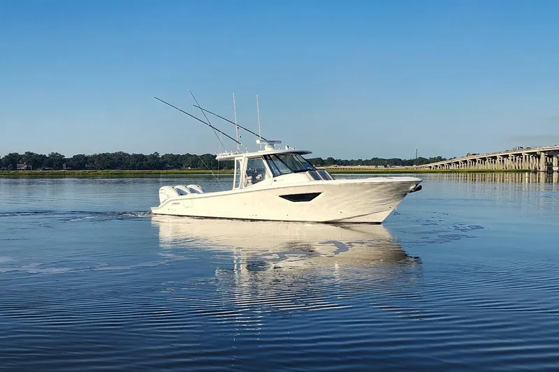 Slide: The Image of 2023 Pursuit S 378 Sport boat on calm water near a bridge. - 34