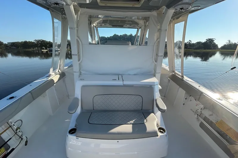 Slide: The Image of 2023 Pursuit S 378 Sport boat interior with cushioned seating and scenic water view. - 7