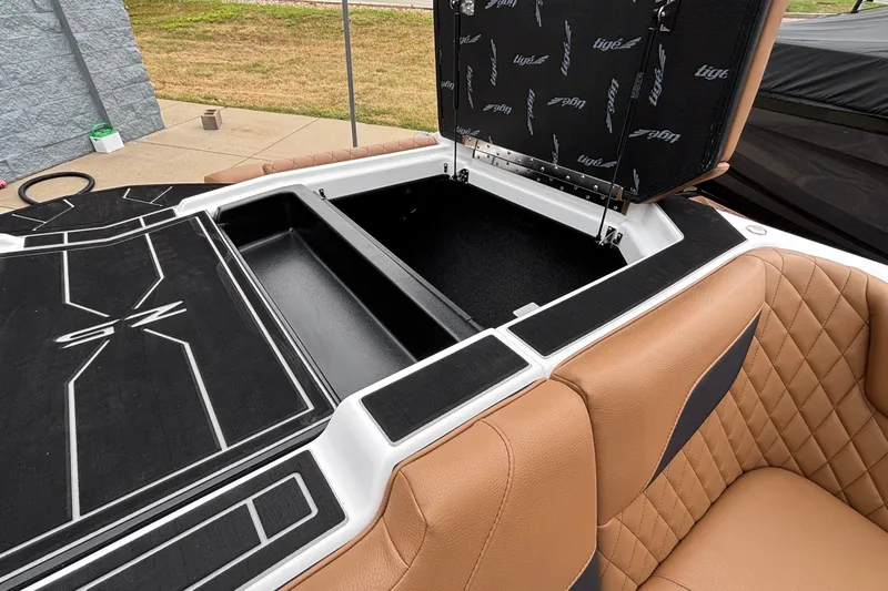 Slide: The Image of 2026 Tigé Z5 boat interior with open storage compartment and tan quilted seating. - 34