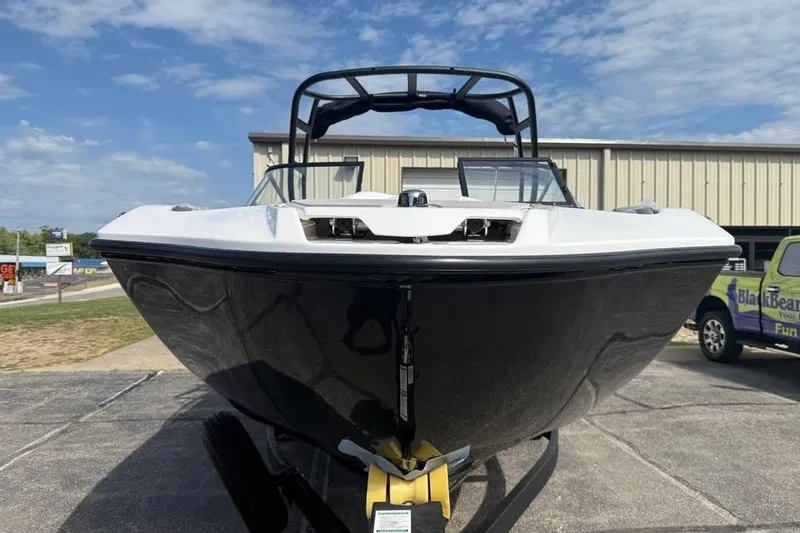 Slide: The Image of 2026 Yamaha Boats AR250, sleek black and white design, parked outdoors under blue sky. - 2