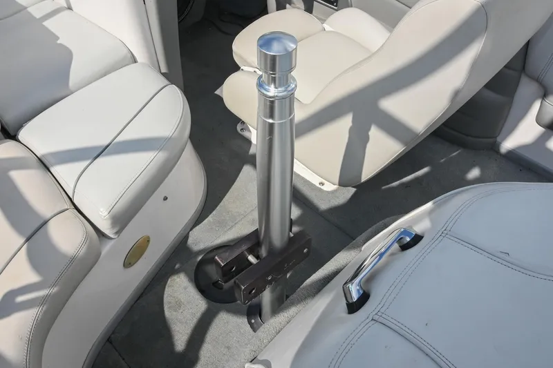 Slide: The Image of Interior of a 2004 Supra Launch SS boat with beige seating and a central metal pole. - 14