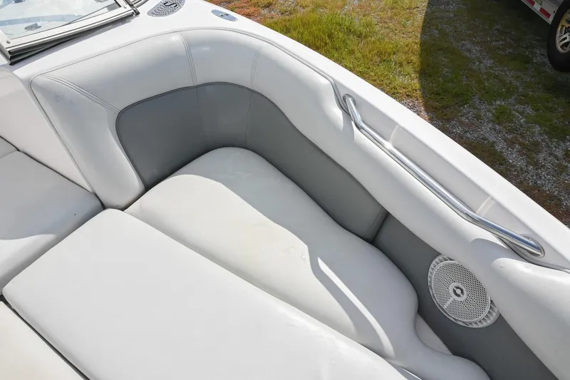 Slide: The Image of 2004 Supra Launch SS boat interior with white and gray seating, speaker, and metal handle. - 24