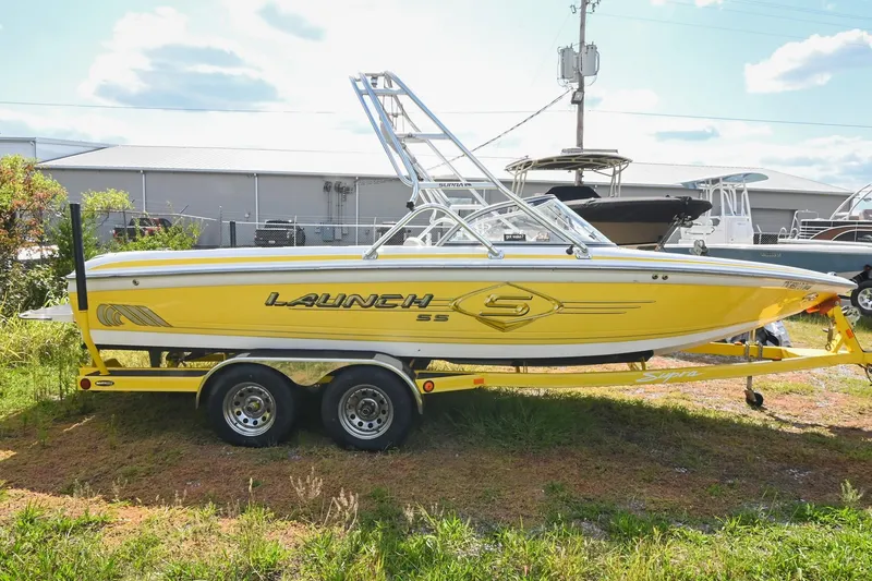 Slide: The Image of Yellow 2004 Supra Launch SS boat on trailer, parked outdoors. - 4