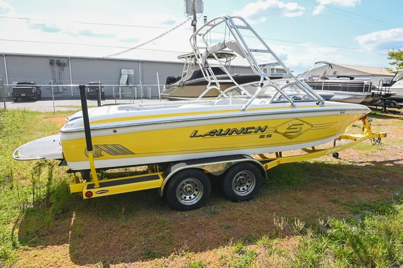 Slide: The Image of Yellow 2004 Supra Launch SS boat on trailer, parked outdoors. - 5