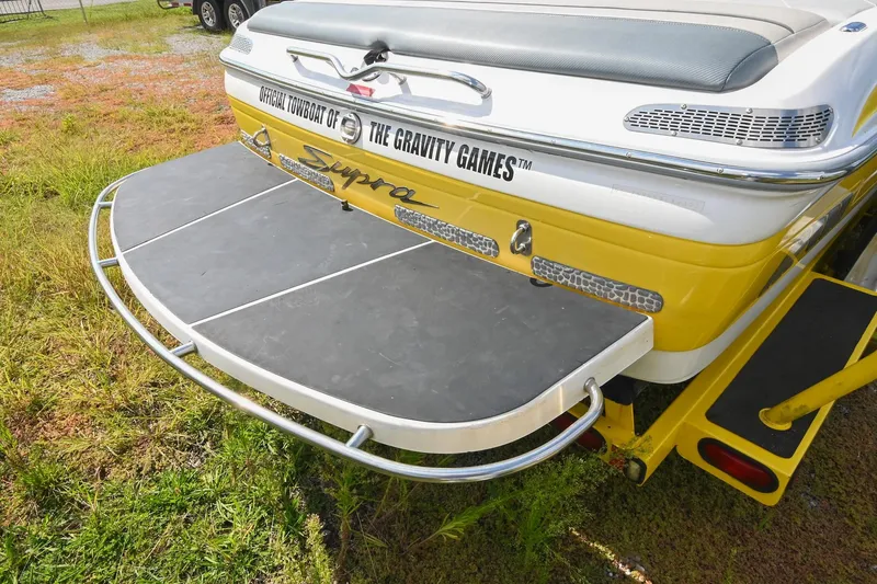 Slide: The Image of 2004 Supra Launch SS boat rear view with swim platform and Gravity Games branding. - 6