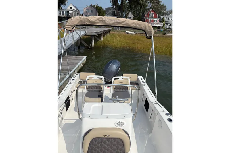 Slide: The Image of 2022 Tidewater 180 CC Adventure boat docked near waterfront homes. - 5