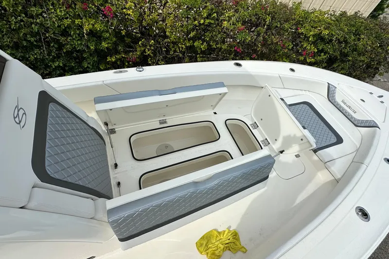 Slide: The Image of 2026 ShearWater 270 SS Open boat interior with open storage compartments and cushioned seating. - 10