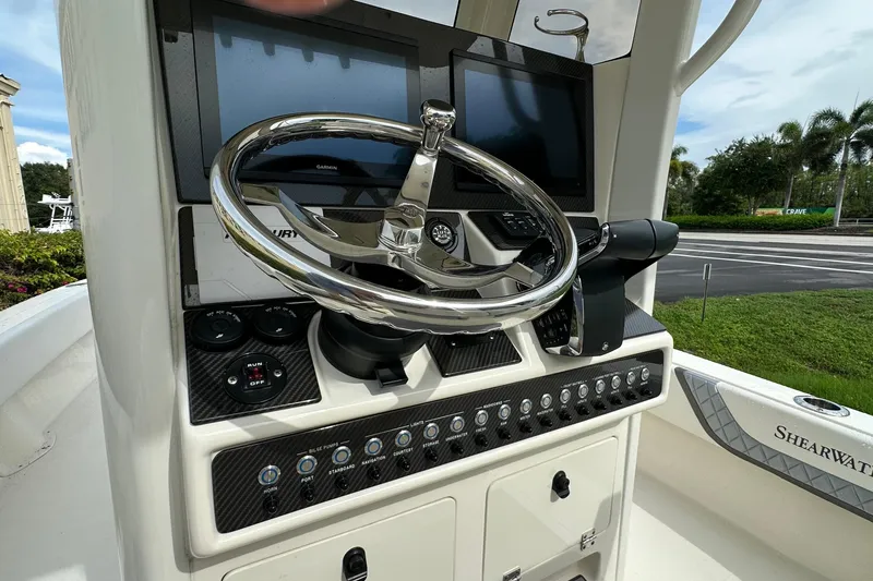 Slide: The Image of 2026 ShearWater 270 SS Open boat dashboard with steering wheel and control panel. - 23
