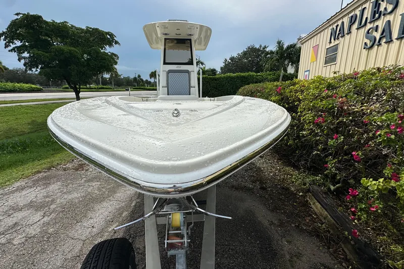 Slide: The Image of 2026 ShearWater 270 SS Open boat on trailer, parked near greenery and building. - 5