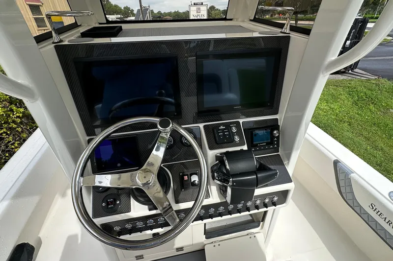Slide: The Image of 2026 ShearWater 270 SS Open boat dashboard with steering wheel and electronic displays. - 7