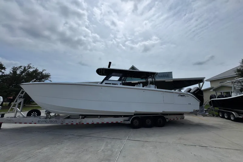 The Image of 2026 Invincible 40 Catamaran on trailer, parked outdoors under cloudy sky. - 1