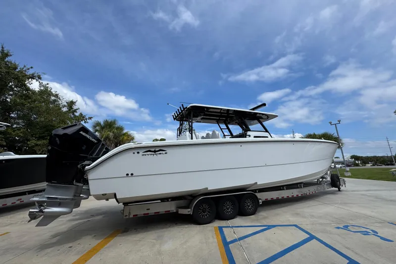 Slide: The Image of 2026 Invincible 40 Catamaran on trailer, parked outdoors under a clear blue sky. - 11