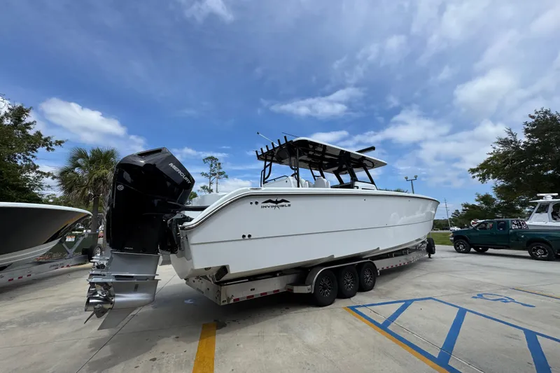 Slide: The Image of 2026 Invincible 40 Catamaran on trailer, parked outdoors under a clear blue sky. - 12