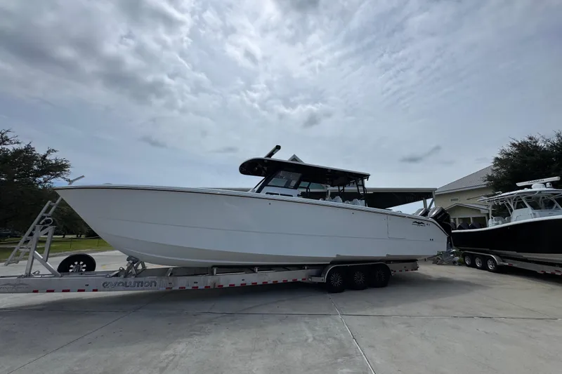 Slide: The Image of 2026 Invincible 40 Catamaran on trailer, parked outdoors under cloudy sky. - 2