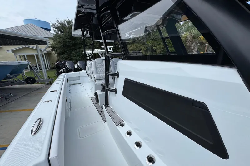 Slide: The Image of 2026 Invincible 40 Catamaran, sleek white deck, modern design, docked outdoors. - 26