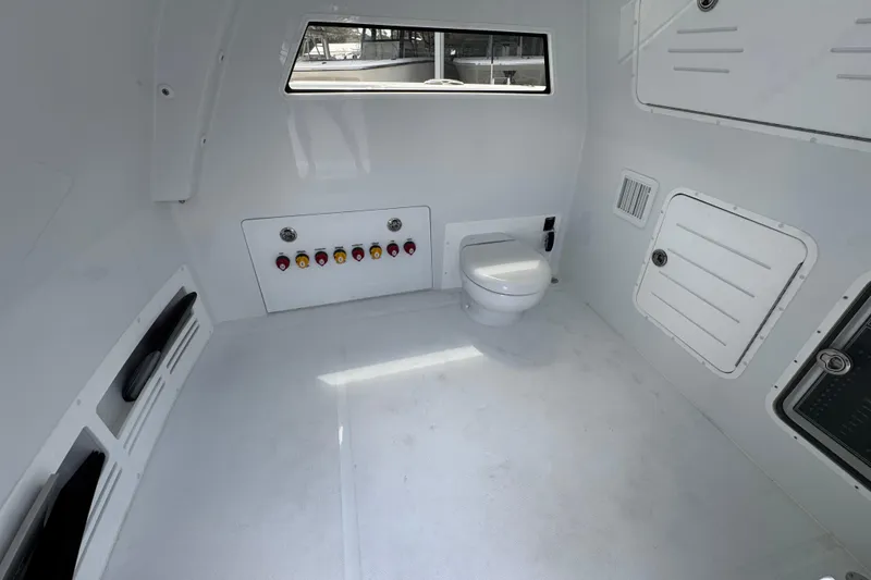 Slide: The Image of Interior of 2026 Invincible 40 Catamaran featuring a compact marine toilet. - 27