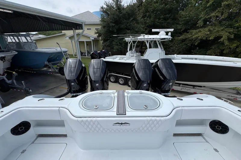 Slide: The Image of 2026 Invincible 40 Catamaran with four powerful Mercury outboard engines, docked near other boats. - 42