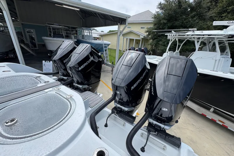 Slide: The Image of Four Mercury outboard engines on a 2026 Invincible 40 Catamaran, docked near other boats. - 43
