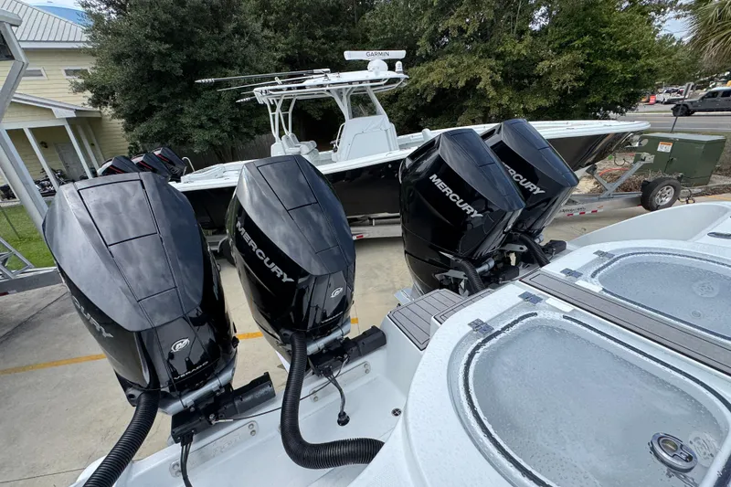 Slide: The Image of 2026 Invincible 40 Catamaran with four Mercury outboard engines, docked outdoors. - 44