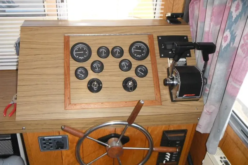 Slide: The Image of 1985 Boatel Hercules Custom boat dashboard with gauges, steering wheel, and throttle controls. - 2