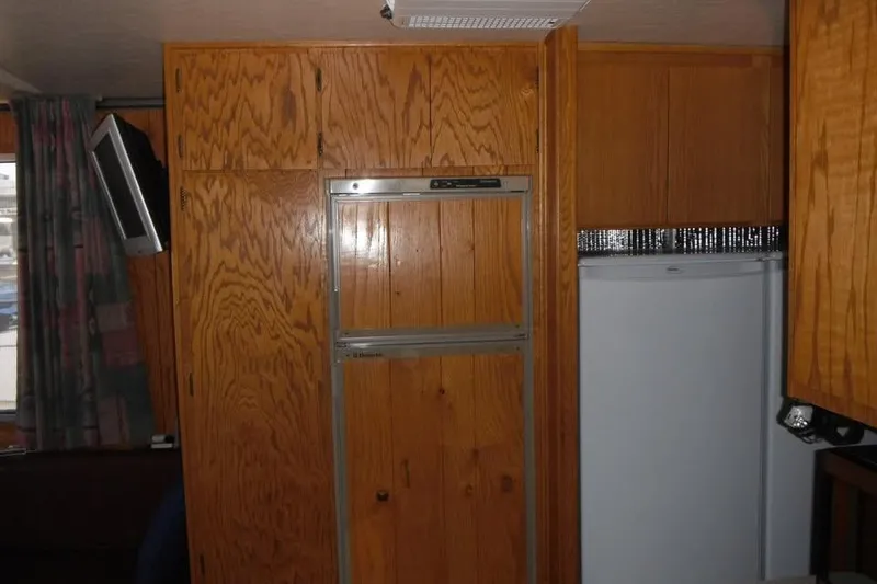 Slide: The Image of Interior of 1985 Boatel Hercules Custom with wooden cabinetry and mounted TV. - 3