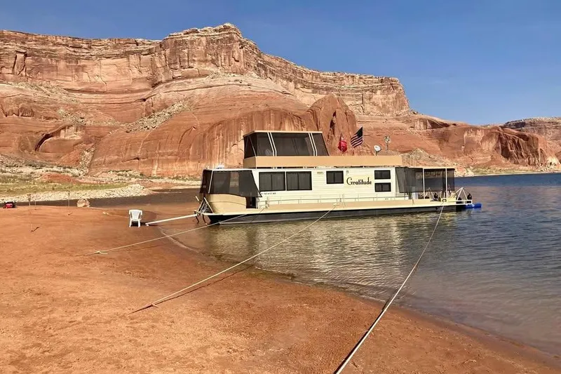 Slide: The Image of 1985 Boatel Hercules Custom houseboat moored by red rock cliffs and calm water. - 4