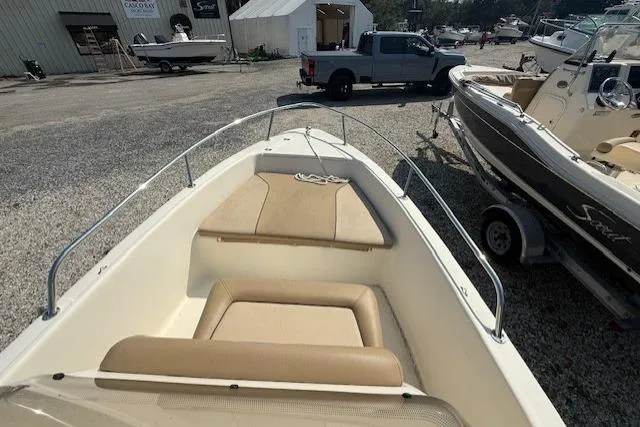 Slide: The Image of 2016 Scout 175 Sportfish boat with beige seating, parked on gravel near a truck. - 4