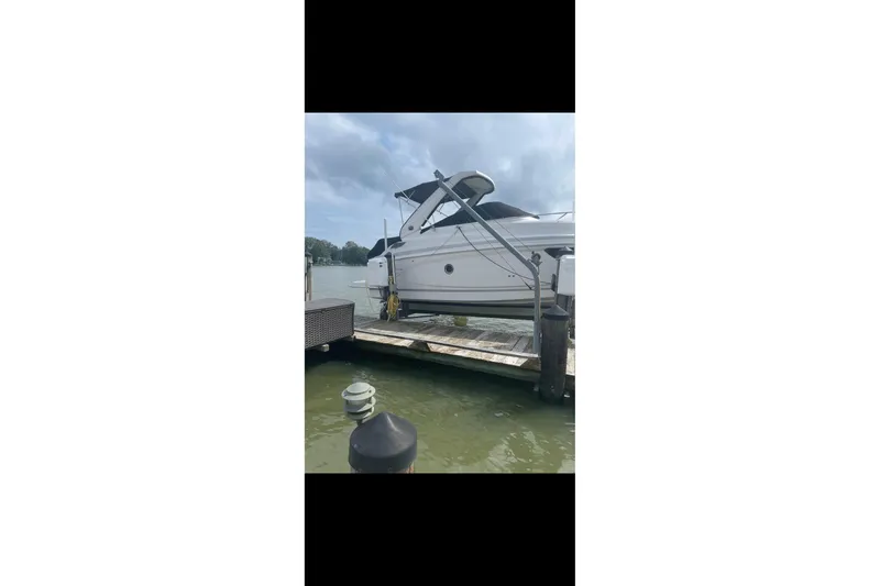 The Image of 2019 Regal 28 Express boat on a trailer in a marina setting under a blue sky. - 0