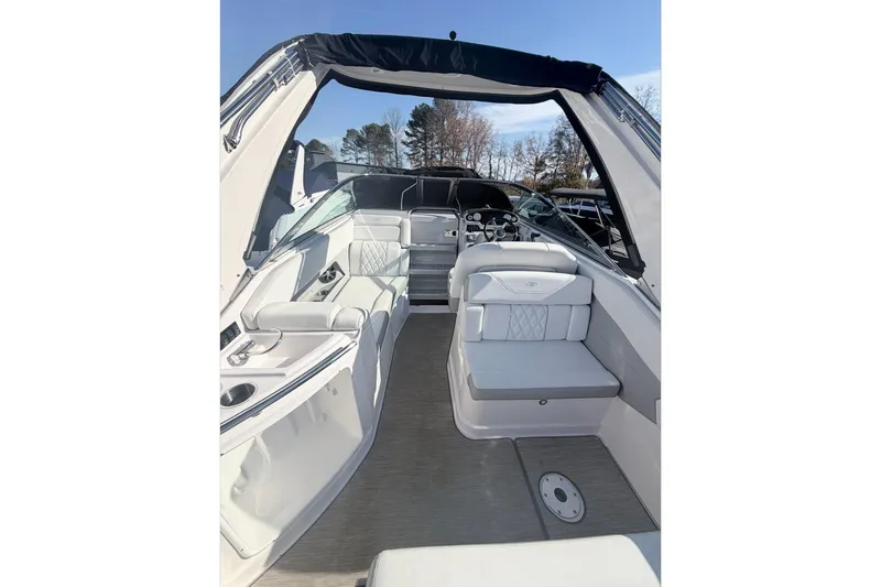 Slide: The Image of 2019 Regal 28 Express boat interior with seating and helm, under clear blue sky. - 17