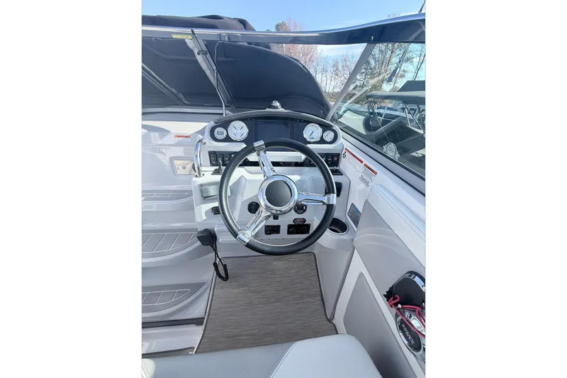 Slide: The Image of 2019 Regal 28 Express boat cockpit with steering wheel and dashboard controls. - 20