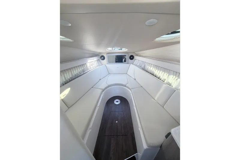 Slide: The Image of 2019 Regal 28 Express boat interior with white seating and wood flooring. - 23