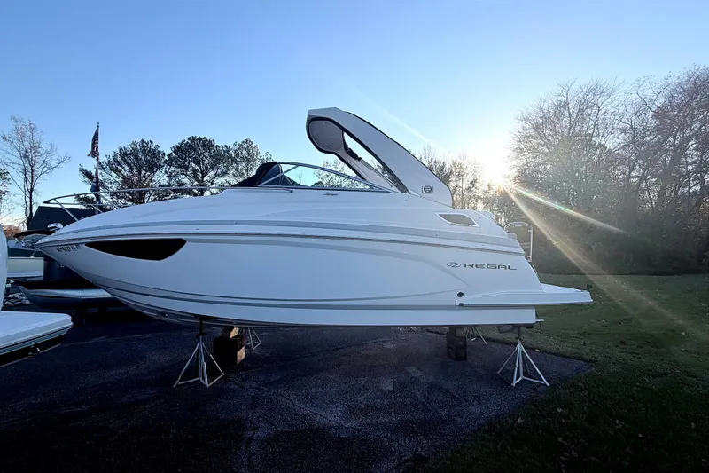 Slide: The Image of 2019 Regal 28 Express boat on stands, sunlit background, parked outdoors. - 26